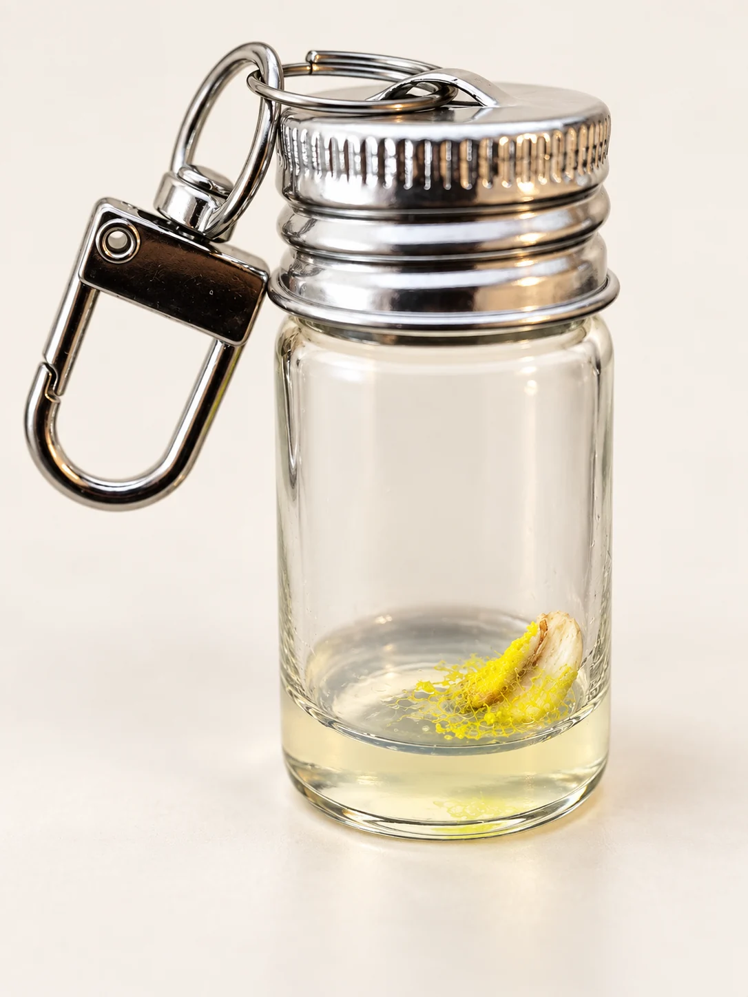 Close-up of the glass Xenling vial, with yellow slime branching towards an oat flake